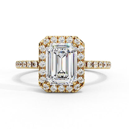 Gold ring with emerald-cut diamond and smaller diamonds on a white background