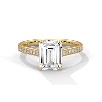 Gold ring with a large diamond and smaller diamonds on the band against a white background