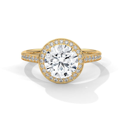 Gold ring with a large diamond and smaller diamonds on the band against a white background