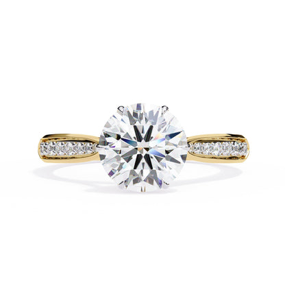 Gold ring with a large diamond and smaller diamonds on the band against a white background
