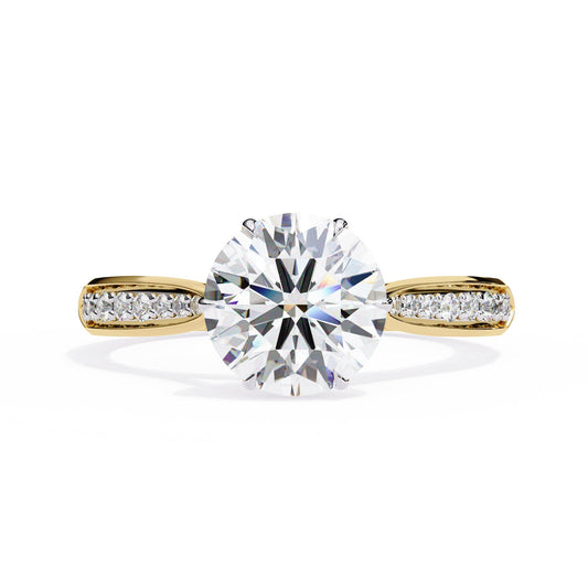 Gold ring with a large diamond and smaller diamonds on the band against a white background