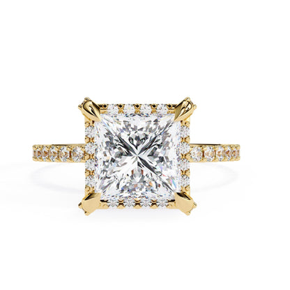 Gold ring with a large diamond and smaller diamonds on the band against a white background