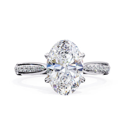 Diamond ring with two large oval diamonds and smaller diamonds on the band against a white background
