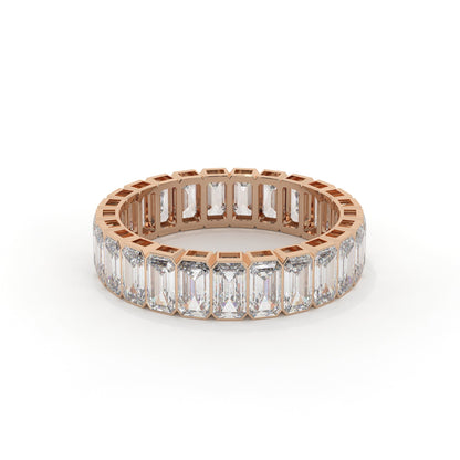 Rose gold ring with emerald-cut diamonds on a white background
