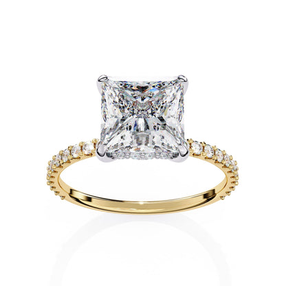 Gold ring with a large diamond and smaller diamonds on the band against a white background